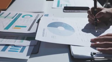 Ofiste çalışan denetçi ve muhasebeci ekibi mali verileri ve muhasebe kayıtlarını hesap makinesiyle analiz ediyor. Muhasebe şirketi kârlı nakit akışı için finansman ve vergilendirme planlaması sağlıyor