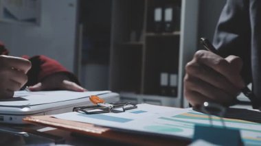 Ofiste çalışan denetçi ve muhasebeci ekibi mali verileri ve muhasebe kayıtlarını hesap makinesiyle analiz ediyor. Muhasebe şirketi kârlı nakit akışı için finansman ve vergilendirme planlaması sağlıyor