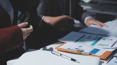 Ofiste çalışan denetçi ve muhasebeci ekibi mali verileri ve muhasebe kayıtlarını hesap makinesiyle analiz ediyor. Muhasebe şirketi kârlı nakit akışı için finansman ve vergilendirme planlaması sağlıyor