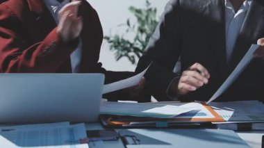 Ofiste çalışan denetçi ve muhasebeci ekibi mali verileri ve muhasebe kayıtlarını hesap makinesiyle analiz ediyor. Muhasebe şirketi kârlı nakit akışı için finansman ve vergilendirme planlaması sağlıyor