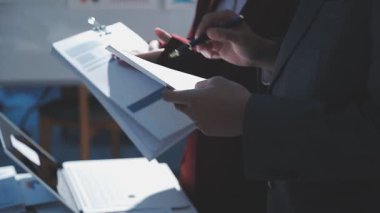 Ofiste çalışan denetçi ve muhasebeci ekibi mali verileri ve muhasebe kayıtlarını hesap makinesiyle analiz ediyor. Muhasebe şirketi kârlı nakit akışı için finansman ve vergilendirme planlaması sağlıyor