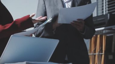 Ofiste çalışan denetçi ve muhasebeci ekibi mali verileri ve muhasebe kayıtlarını hesap makinesiyle analiz ediyor. Muhasebe şirketi kârlı nakit akışı için finansman ve vergilendirme planlaması sağlıyor