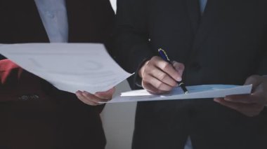 Ofiste çalışan denetçi ve muhasebeci ekibi mali verileri ve muhasebe kayıtlarını hesap makinesiyle analiz ediyor. Muhasebe şirketi kârlı nakit akışı için finansman ve vergilendirme planlaması sağlıyor