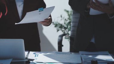 Ofiste çalışan denetçi ve muhasebeci ekibi mali verileri ve muhasebe kayıtlarını hesap makinesiyle analiz ediyor. Muhasebe şirketi kârlı nakit akışı için finansman ve vergilendirme planlaması sağlıyor