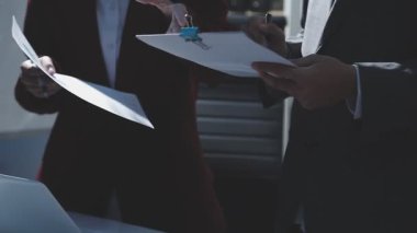 Ofiste çalışan denetçi ve muhasebeci ekibi mali verileri ve muhasebe kayıtlarını hesap makinesiyle analiz ediyor. Muhasebe şirketi kârlı nakit akışı için finansman ve vergilendirme planlaması sağlıyor