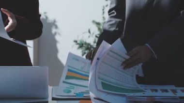 Ofiste çalışan denetçi ve muhasebeci ekibi mali verileri ve muhasebe kayıtlarını hesap makinesiyle analiz ediyor. Muhasebe şirketi kârlı nakit akışı için finansman ve vergilendirme planlaması sağlıyor