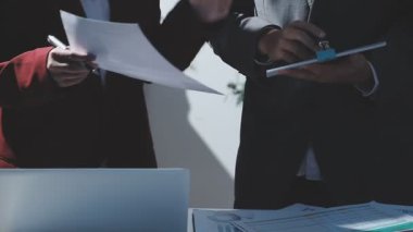 Ofiste çalışan denetçi ve muhasebeci ekibi mali verileri ve muhasebe kayıtlarını hesap makinesiyle analiz ediyor. Muhasebe şirketi kârlı nakit akışı için finansman ve vergilendirme planlaması sağlıyor