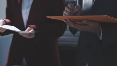 Ofiste çalışan denetçi ve muhasebeci ekibi mali verileri ve muhasebe kayıtlarını hesap makinesiyle analiz ediyor. Muhasebe şirketi kârlı nakit akışı için finansman ve vergilendirme planlaması sağlıyor