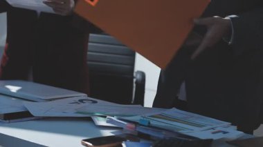 Ofiste çalışan denetçi ve muhasebeci ekibi mali verileri ve muhasebe kayıtlarını hesap makinesiyle analiz ediyor. Muhasebe şirketi kârlı nakit akışı için finansman ve vergilendirme planlaması sağlıyor