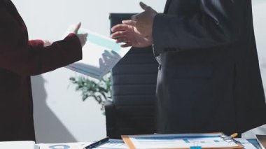 Ofiste çalışan denetçi ve muhasebeci ekibi mali verileri ve muhasebe kayıtlarını hesap makinesiyle analiz ediyor. Muhasebe şirketi kârlı nakit akışı için finansman ve vergilendirme planlaması sağlıyor