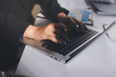 Modern ofiste işbirliği yapan denetçiler, finansal belgeleri analiz ediyorlar ve çizelgeleri gösteren bir dizüstü bilgisayarla hesap makinesi kullanıyorlar. Ticarette denetim ve vergiler