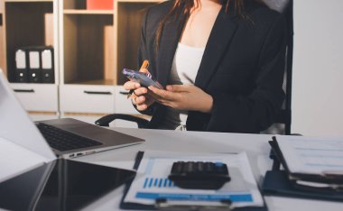 Modern ofiste işbirliği yapan denetçiler, finansal belgeleri analiz ediyorlar ve çizelgeleri gösteren bir dizüstü bilgisayarla hesap makinesi kullanıyorlar. Ticarette denetim ve vergiler