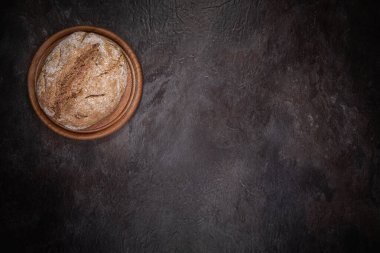 Yuvarlak tahta üzerinde düz ekşi ceviz ekmeği yatıyordu sol üst köşede koyu kayrak yüzeyde. Çerçevenin geri kalanı metin veya tasarım için bir sürü boş alan bırakır.