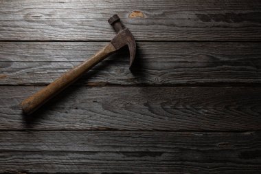 Eski çekiç sol üst köşede, eskimiş ahşabın üzerinde duruyor. El işi ve yıpranmış aletleri vurguluyor. Çerçevenin geri kalanı metin veya tasarım için bir sürü boş alan bırakır.