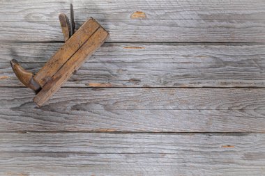 Sol üst köşede duran klasik ahşap el uçağının yukarıdan görünüşü. Çerçevenin geri kalanı metin veya tasarım için bir sürü boş alan bırakır.