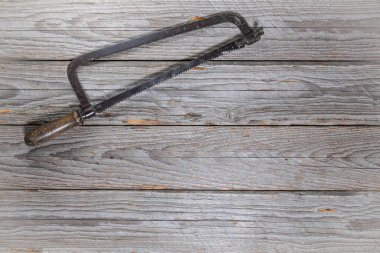 Sol üst köşesinde ahşap saplı eski tip tek elli testere manzarası. Çerçevenin geri kalanı metin veya tasarım için bir sürü boş alan bırakır.