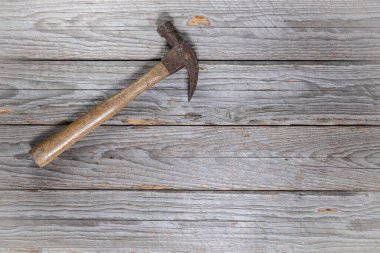 Sol üst köşesinde ahşap saplı paslı eski çekiç. Çerçevenin geri kalanı metin veya tasarım için bir sürü boş alan bırakır.