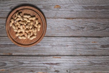 Sol üst köşeye yerleştirilmiş fıstık kabuklu ahşap tahta. Çerçevenin geri kalanı metin veya tasarım için bir sürü boş alan bırakır.