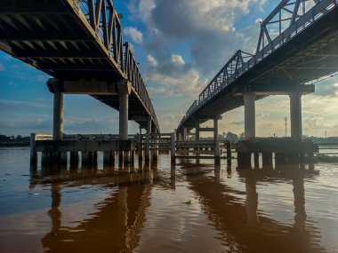 Kapuas Çifte Köprüleri kısmen suya batmış devasa silindirik beton sütunlar tarafından desteklenmektedir. Altındaki su mükemmel bir şekilde arka plan aydınlatması ve siluetler oluşturuyor.