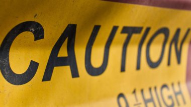 Bright yellow caution sign alerts to danger