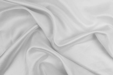 Beyaz kumaş pürüzsüz bir yüzeyde akıyor.
