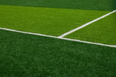 Açık yeşil futbol sahası belirgin çim desenleri gösteriyor