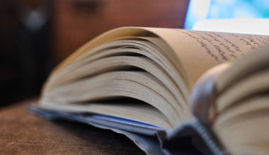 Yumuşak ışıkta, ahşap bir masada açık bir kitap. Yüksek kalite fotoğraf