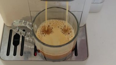 Evde modern bir makineyle zengin kahve yapmak. Yüksek kalite 4k görüntü