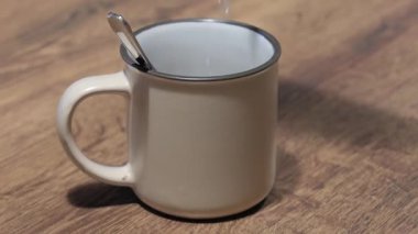 İçinde kaşık olan bir kahve bardağına sıcak su dökmek. Yüksek kalite 4k görüntü