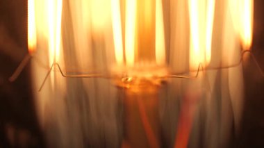 Bir ampul filamanının koyu bir ışıkta parlayan makro görüntüsü.