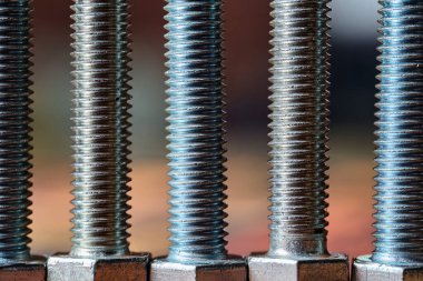 Dikey bir satırda dizilmiş metalik vida ipliklerine yakın çekim seçici odak