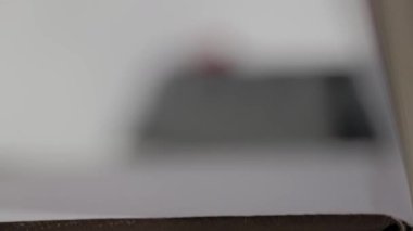 Kalın bir kitabın içinde sığ bir alan derinliği ile dönen kağıt sayfaların uç makro görüntüsü