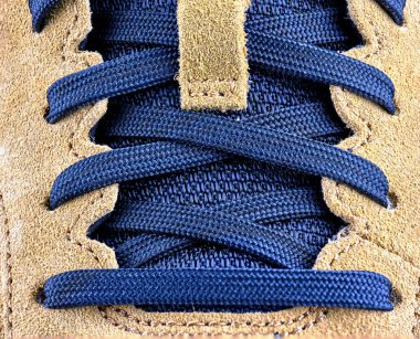 Üstten makro mavi bağcıkların çapraz çapraz bir dil ve ten rengi deri paneller.