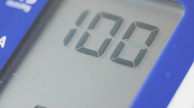 Tansiyon ölçümlerini ve kalp atışlarını gösteren dijital bir tonometrenin makro videosu