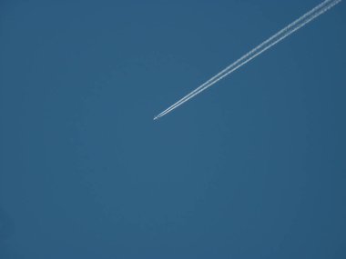 Mavi gökyüzünde mavi beyaz bir uçak