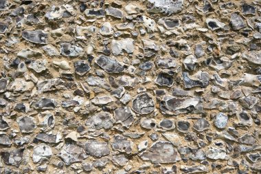 Doğal taş dokusunu ve kırsal deseni gösteren geleneksel çakmaktaşı duvarına yakın çekim.