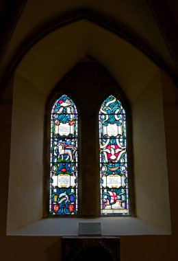 Portsmouth, Hampshire, İngiltere. 12 Haziran 2025. Simgesel Şekiller ve Zengin Renkli İkiz Panelli Lekeli Cam Pencere Portsmouth Katedrali