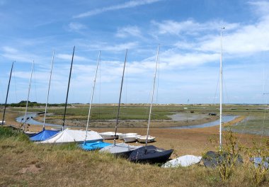 Batı Wittering, Batı Sussex, İngiltere. 17 Haziran 2025. Botlar ve yelkenli botlar Low Tide 'da demirli, Snowhill Creek Estuary, West Wittering