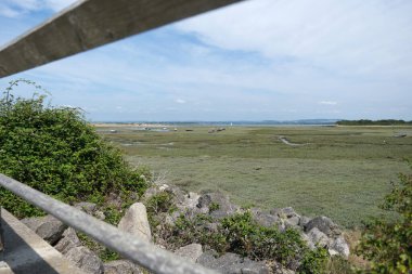 Geniş Kıyı Bataklığı Manzarası Ahşap korkuluk ve kayalar tarafından çerçevelenmiş
