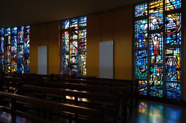 Newcastle, County Down, Kuzey İrlanda. 6 Ekim 2025. Newcastle Kuzey İrlanda 'da canlı vitray pencereleri ve ahşap sıraları olan Varsayım Kilisesinin İçi