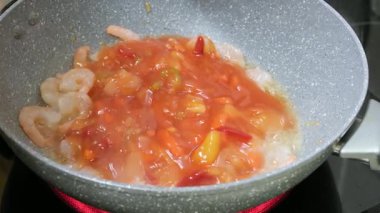 Tatlı ve Ekşi Sosu ve Sebzeleri Cızırdayan Karideslerin üzerine dökerek