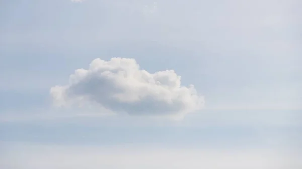 Ett fluffigt moln på en ljusblå himmel panorama bakgrund — Stockfoto