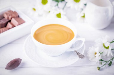 Sütlü, çikolatalı ve sonbahar kasımpatı çiçekli kahve beyaz arka planda