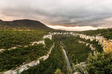 Burgos 'taki Ebro Nehri kanyon kayalıklarının uzun süreli panoramik görüntüsü, dramatik günbatımı gökyüzü