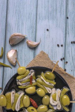 Geleneksel Bask Gilda Şiş Ançüez zeytin ve biberli Kırsal ahşap masa üzerinde aperatif