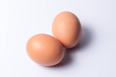 Beyaz arka planda taze yumurtalar, izole ve iyi aydınlatılmış. Yemek, beslenme, ev yemeği, doğal malzemeler ve sağlıklı beslenme kavramlarını temsil etmek için ideal görüntü..