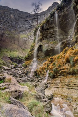 Alava 'daki Delika Kanyonu' nun kayalık uçurumlarından akan güzel bir şelalenin uzun görüntüsü.