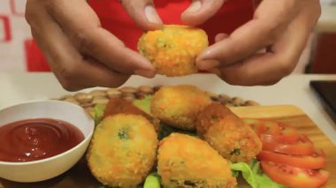 Bir insan peynir içeren yiyeceği keser.