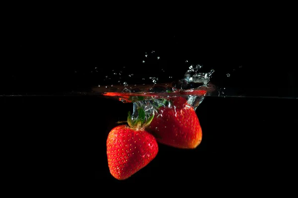 Fresas salpicando en el agua —  Fotos de Stock