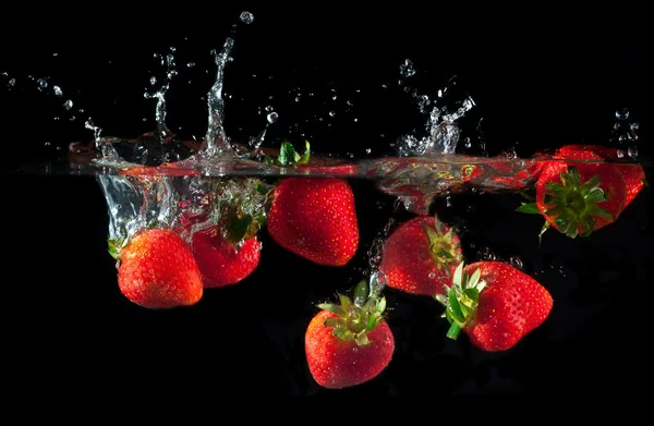 Erdbeeren, die ins Wasser spritzen — Stockfoto